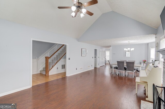 3095 Willow Park Dr, Dacula, GA 30019 - living area with high vaulted ceiling, wood finished floors, stairs, ceiling fan with notable chandelier, and a wealth of natural light