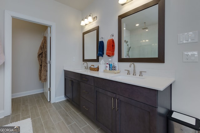 bathroom with a stall shower, baseboards, and double vanity