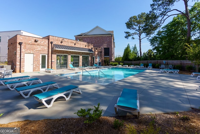 community pool featuring fence and a patio area