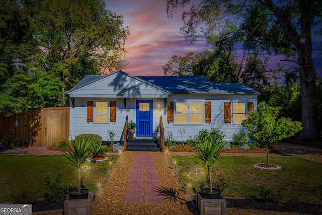 bungalow-style home featuring fence and a front yard