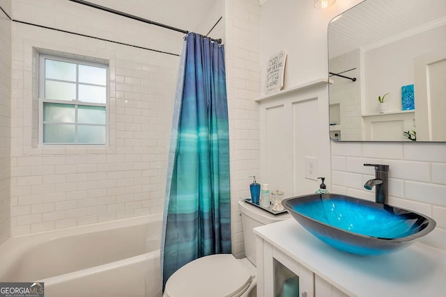 bathroom featuring crown molding, shower / bath combo with shower curtain, toilet, and vanity