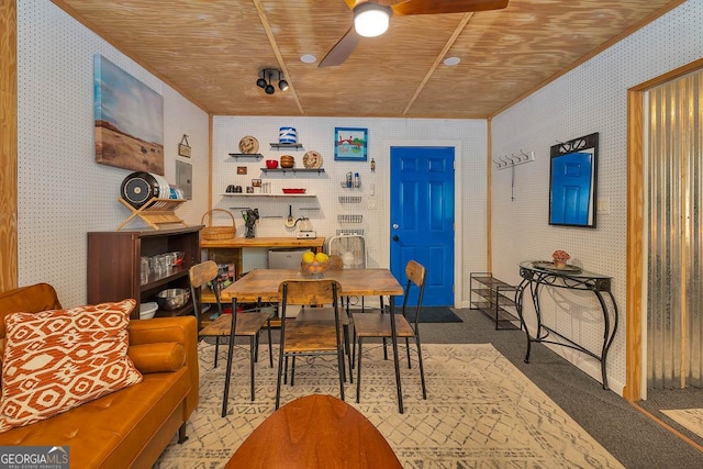 carpeted dining space with wallpapered walls, wooden ceiling, and ceiling fan