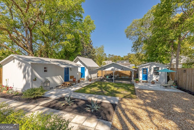 back of house featuring an outdoor structure, entry steps, a patio area, and fence