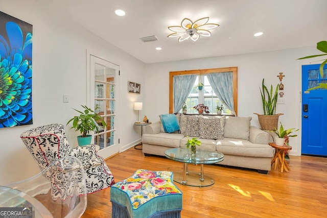 living room with recessed lighting, wood finished floors, visible vents, and baseboards