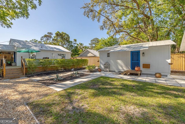 rear view of house with a patio area, fence, a yard, and a deck