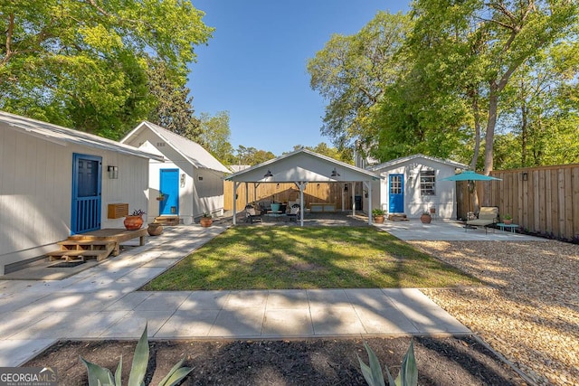 back of property featuring an outbuilding, a patio, and fence