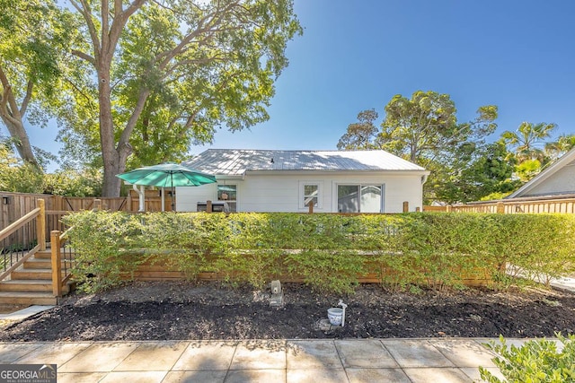 view of front of home with metal roof and fence