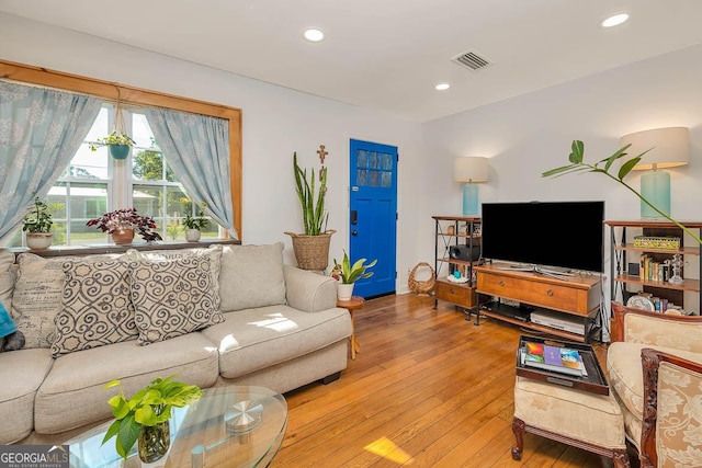 living area with recessed lighting, light wood-style floors, and visible vents