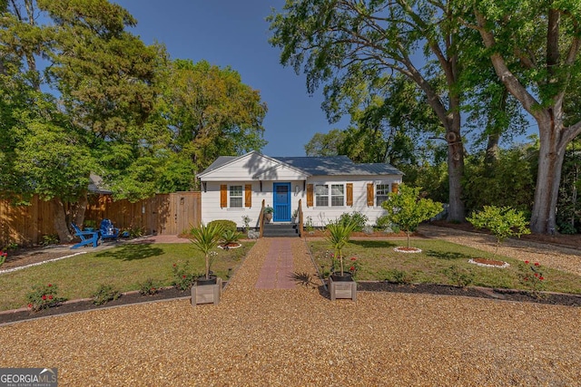 view of front of property with fence and a front lawn