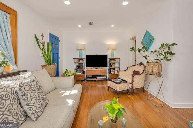 living area featuring wood-type flooring, visible vents, baseboards, and recessed lighting