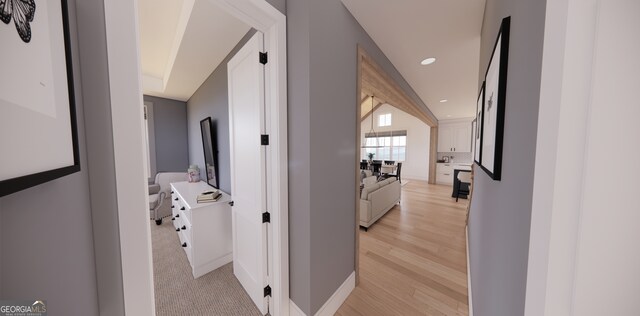 hall featuring recessed lighting, baseboards, and light wood-style flooring