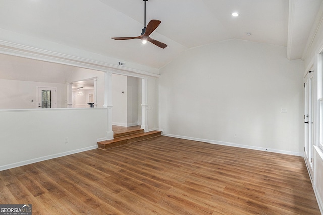 unfurnished living room featuring wood finished floors, ornate columns, visible vents, ceiling fan, and vaulted ceiling