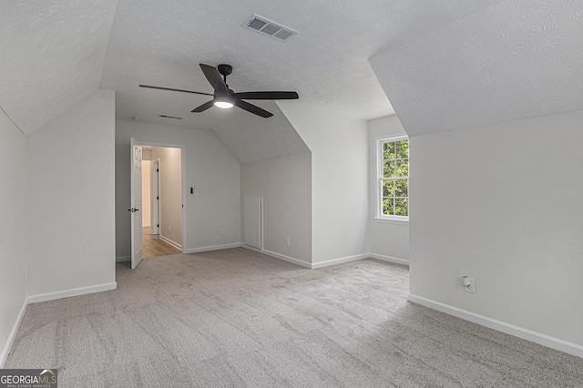 additional living space featuring carpet, visible vents, lofted ceiling, and ceiling fan
