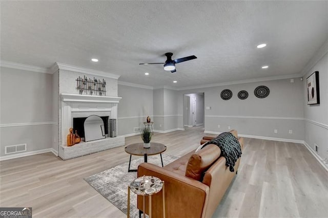 780 N Ola Rd, Mcdonough, GA 30252 - living room featuring light wood-type flooring, recessed lighting, a ceiling fan, a textured ceiling, and a fireplace