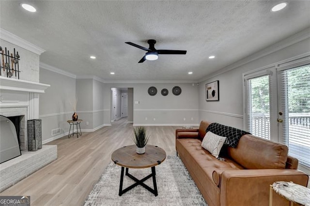 780 N Ola Rd, Mcdonough, GA 30252 - living room with light wood finished floors, a ceiling fan, recessed lighting, a fireplace, and a textured ceiling
