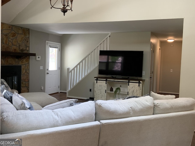 426 Shenendoa Dr, Ellijay, GA 30540 - living area featuring stairway, wood finished floors, vaulted ceiling, and a stone fireplace