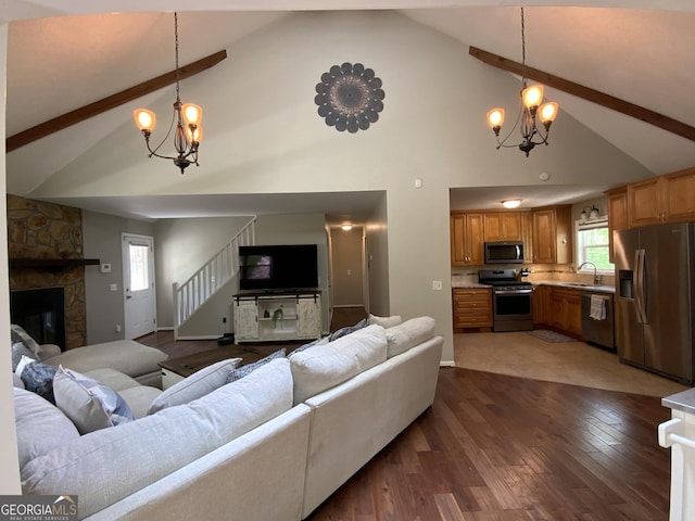 426 Shenendoa Dr, Ellijay, GA 30540 - living area featuring a chandelier, high vaulted ceiling, beamed ceiling, a stone fireplace, and dark wood-style floors