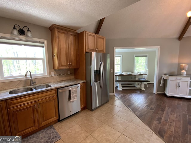 426 Shenendoa Dr, Ellijay, GA 30540 - kitchen with stainless steel appliances, vaulted ceiling, brown cabinets, a textured ceiling, and light countertops