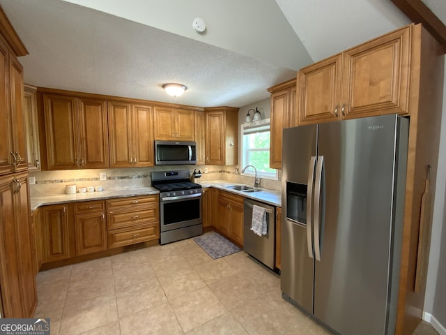 426 Shenendoa Dr, Ellijay, GA 30540 - kitchen featuring stainless steel appliances, brown cabinets, light countertops, backsplash, and a textured ceiling