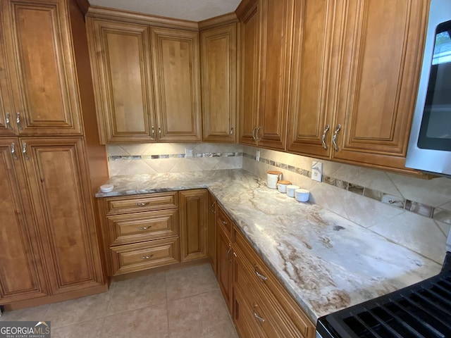 426 Shenendoa Dr, Ellijay, GA 30540 - kitchen featuring brown cabinets, light stone counters, decorative backsplash, and stove