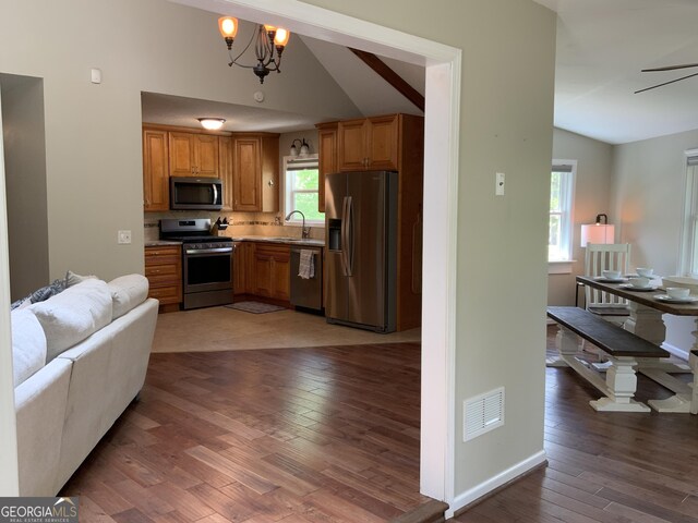 426 Shenendoa Dr, Ellijay, GA 30540 - kitchen with appliances with stainless steel finishes, vaulted ceiling, light wood-type flooring, open floor plan, and brown cabinets