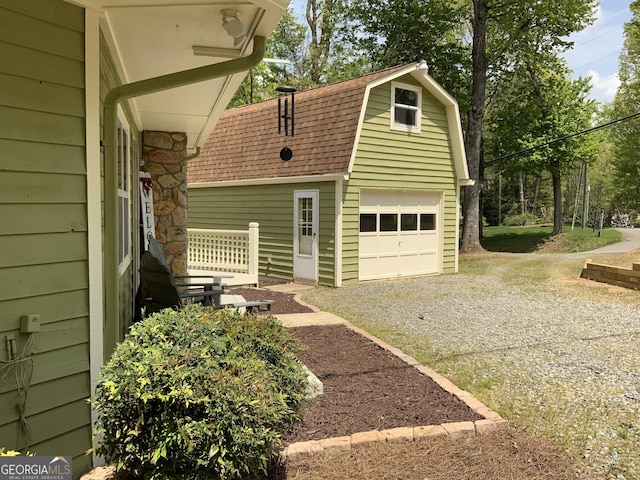 426 Shenendoa Dr, Ellijay, GA 30540 - view of side of home featuring a gambrel roof, roof with shingles, a garage, an outbuilding, and gravel driveway
