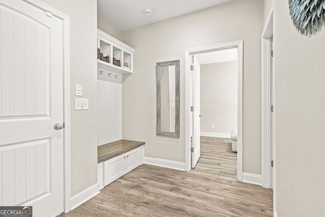 mudroom featuring light wood-style flooring and baseboards