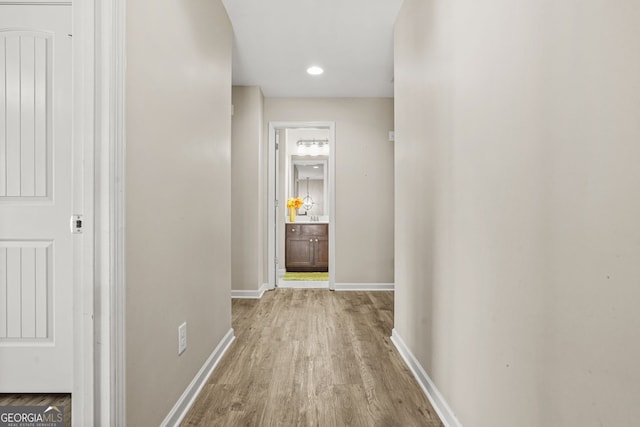 hall featuring recessed lighting, wood finished floors, and baseboards