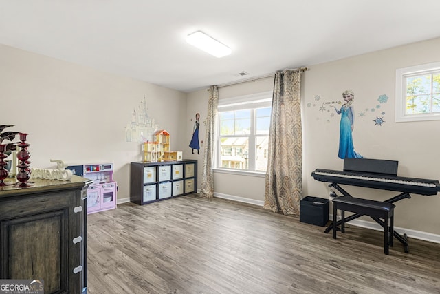 game room with wood finished floors, visible vents, and baseboards
