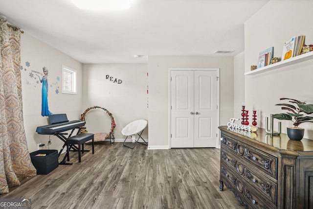 living area featuring wood finished floors, visible vents, and baseboards