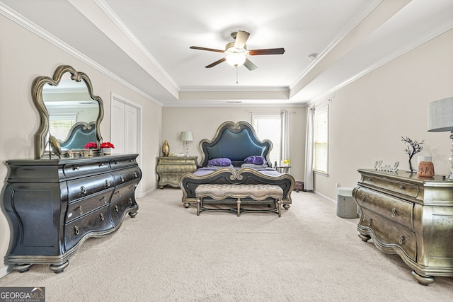 carpeted bedroom featuring a raised ceiling, a ceiling fan, baseboards, and ornamental molding