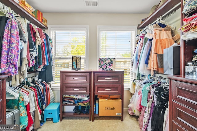 walk in closet with visible vents and light colored carpet