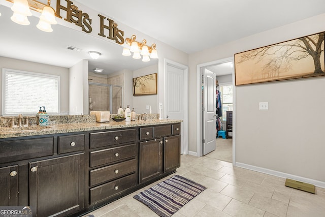 bathroom with baseboards, visible vents, a sink, and a stall shower