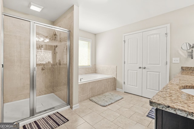 bathroom with a shower stall, a bath, tile patterned floors, and vanity