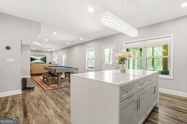 kitchen with wood finished floors, a healthy amount of sunlight, pool table, and baseboards