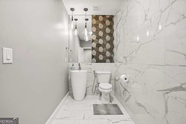 bathroom featuring marble finish floor, toilet, visible vents, and baseboards