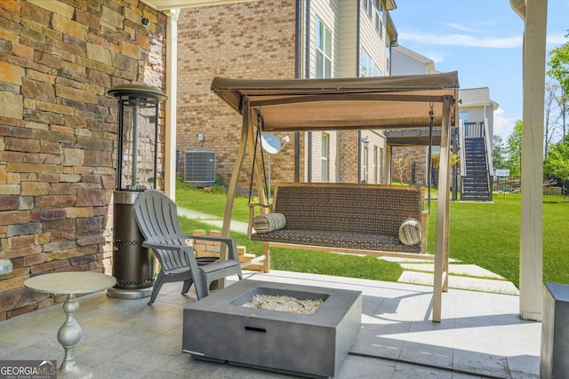view of patio with stairs, cooling unit, and an outdoor fire pit