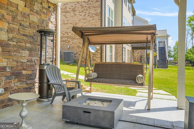 view of patio / terrace featuring a fire pit, stairway, and central AC unit