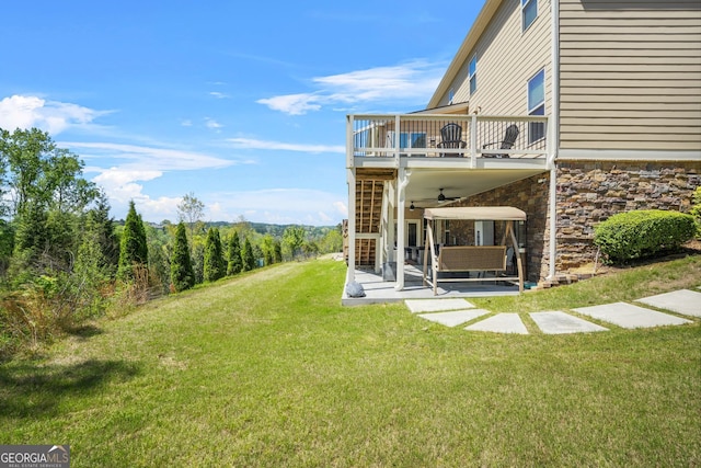 view of yard with ceiling fan, a balcony, and a patio