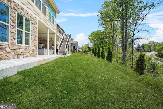 view of yard featuring a patio area, stairs, and ceiling fan