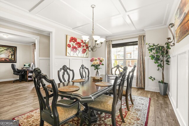dining area featuring light wood finished floors, an inviting chandelier, coffered ceiling, beamed ceiling, and a decorative wall