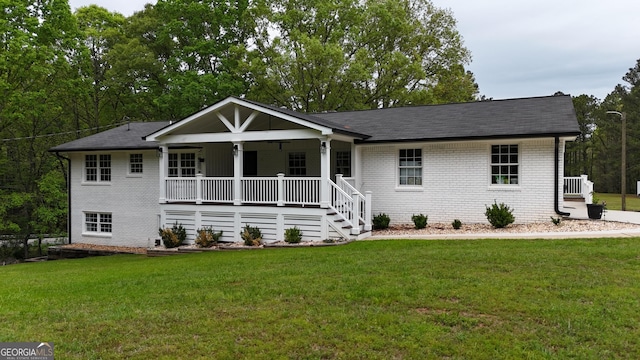 view of front of home featuring brick siding, covered porch, a front lawn, stairs, and a shingled roof