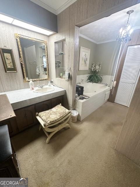 bathroom with a chandelier, a whirlpool tub, vanity, and crown molding
