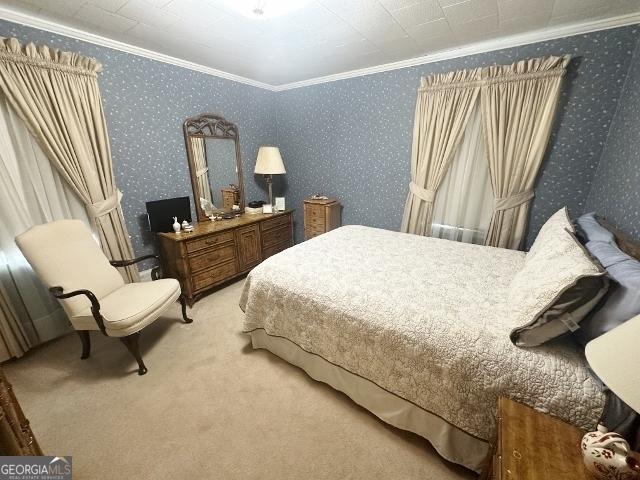 carpeted bedroom with wallpapered walls and ornamental molding