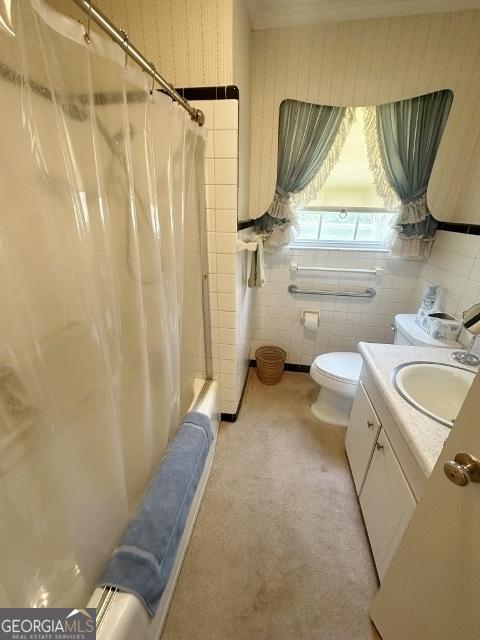 full bathroom with shower / bath combo, toilet, tile walls, wallpapered walls, and vanity