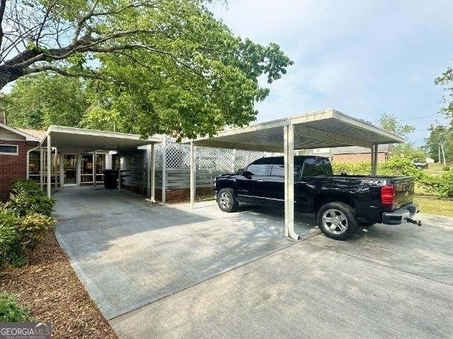 view of parking / parking lot featuring a detached carport and driveway