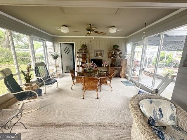 sunroom with plenty of natural light, carpet flooring, and crown molding