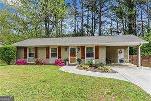 single story home with fence, an attached carport, a front yard, and concrete driveway