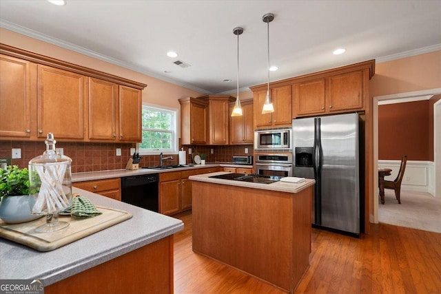 60 Heritage Keep, Covington, GA 30016 - kitchen featuring black appliances, brown cabinetry, pendant lighting, light wood-type flooring, and ornamental molding
