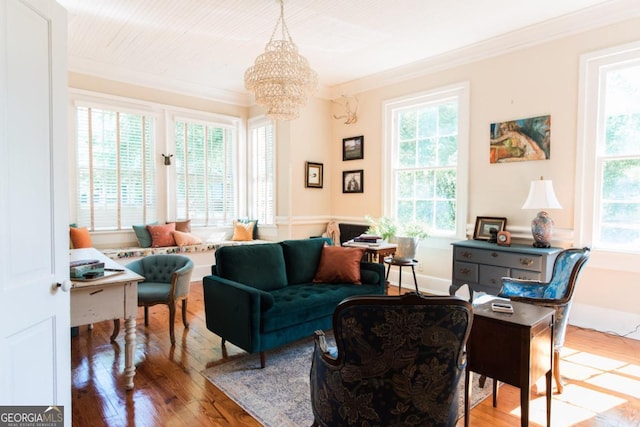 sitting room featuring ornamental molding, plenty of natural light, hardwood / wood-style flooring, and a chandelier